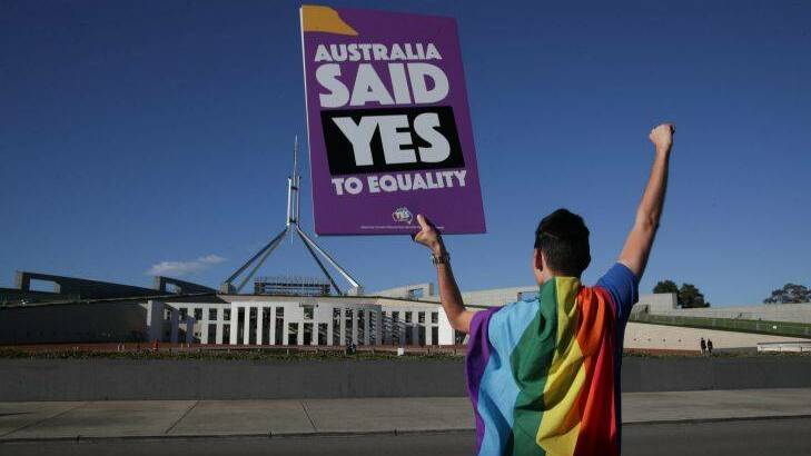 Supporters of same-sex marriage pose for photographers with the rainbow flag during a rally on the front lawn of Parliament House ahead of the vote on the Marriage Amendment Bill, at Parliament House. Photo: Alex Ellinghausen