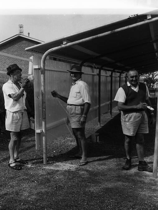 Rotarians John Carroll, Charles Huxley and Norm Payne painting the new built bus shelter, 1964