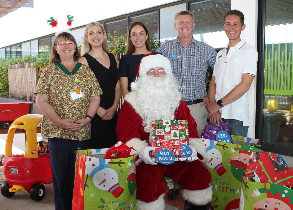 Paediatric Nursing Unit Manager Nicole Leith with Michellie Henry, Erin Schmidt, Brett Varcoe and John Little who delivered a mountain of presents for children in hospital this Christmas. Happy to help Miedecke Motor Group’s Giving Tree appeal was Settlement City’s Santa.