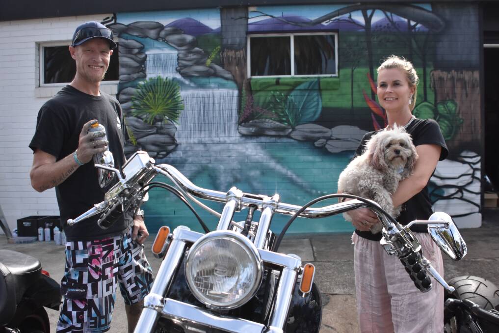MURAL OF TRANQUILITY: Port Macquarie artist Damon Moroney with Nardia Paulson and Ruby, outside Mean Streak Choppers.