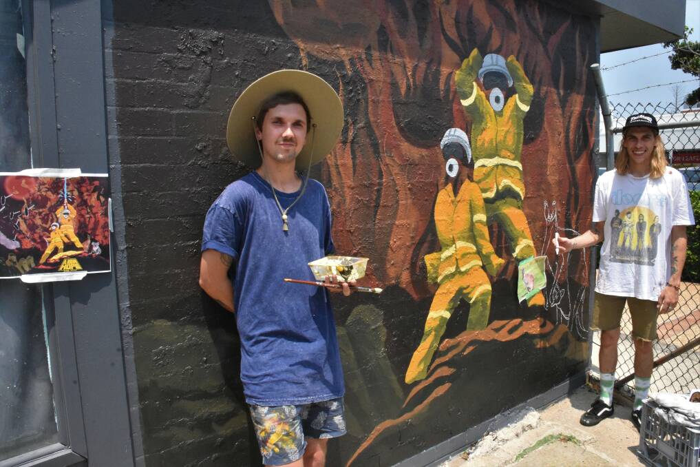 UNDER THE HOT SUN: Port Macquarie artists Brad Collins and Todd Bourke creating the mural in William Street.