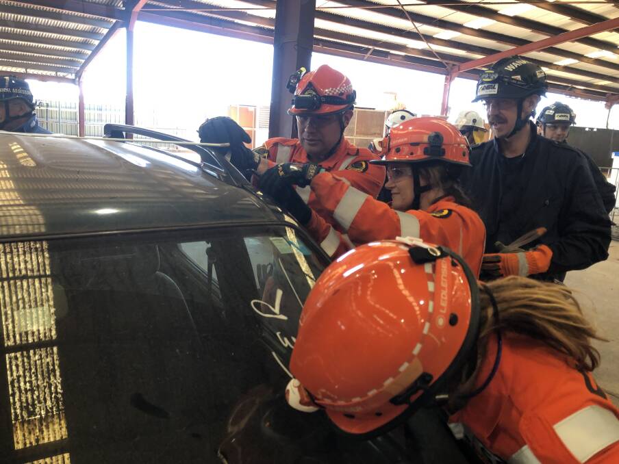 CAR CUTTING: Port Macquarie volunteers gaining access to a car during the Australasian Road Rescue Challenge in Dubbo. Photo; Supplied/Port Macquarie SES.