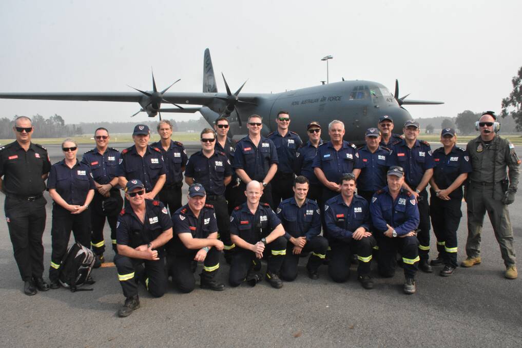 GROUP SNAP: Firefighters gather for a quick pre-flight photo with the C-130 cargo plane.