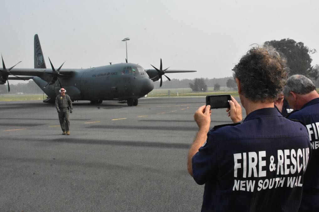 SNAP A SELFIE: Firefighters grab some pictures of the huge C-130 cargo plane.