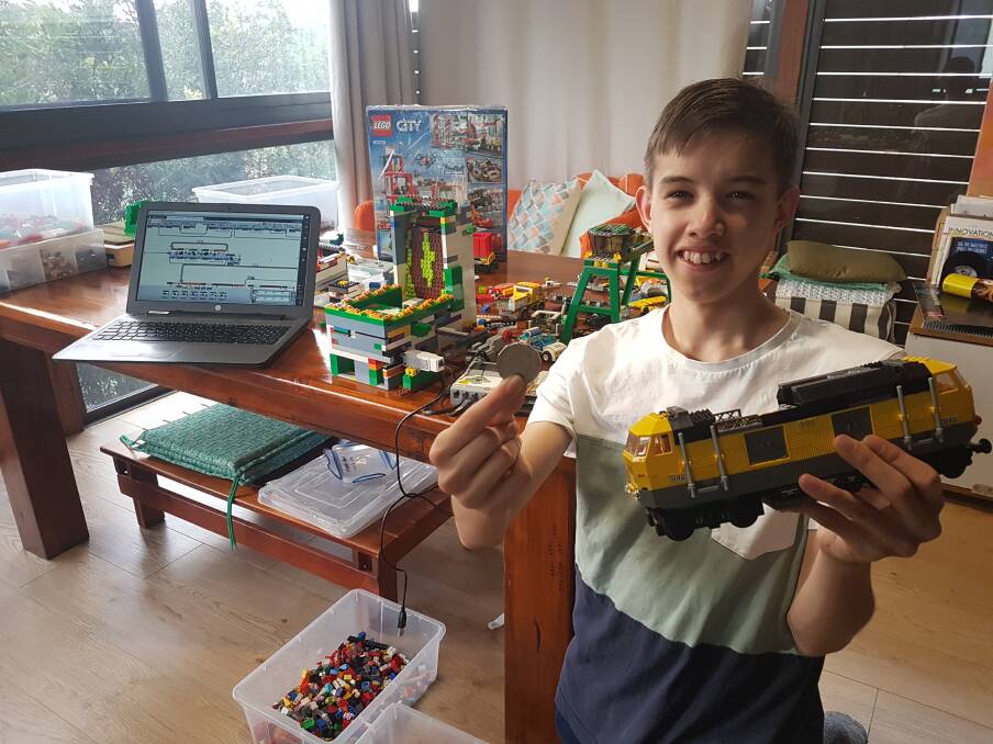 Creative: Zac Morgan prepares LEGO trains and a new arcade machine.