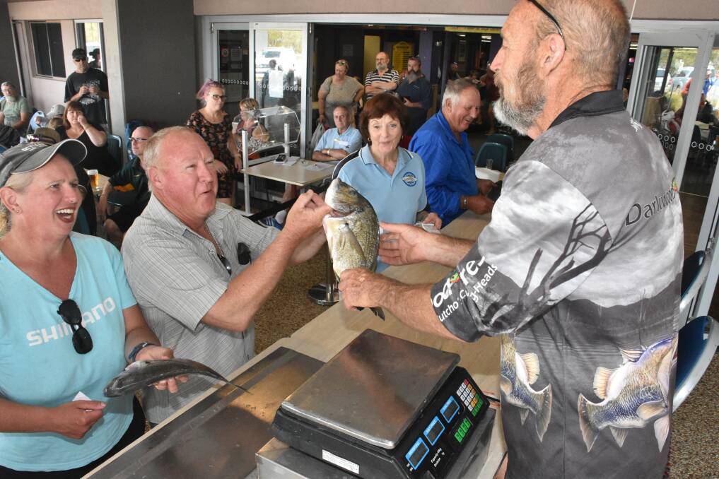 WHAT A FISH: Fisherman Joe Malineack recieves his prize winning bream back from the weigh in.