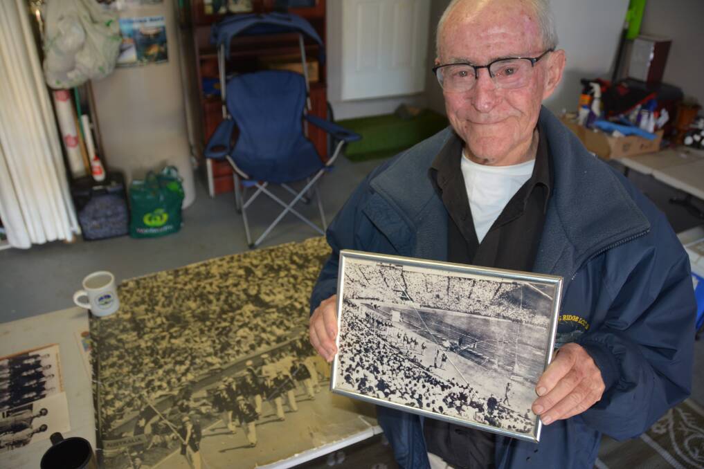 FAMILY PRIDE: Reg McKay with a photo of Les McKay leading the Australian Olympic team in 1948.
