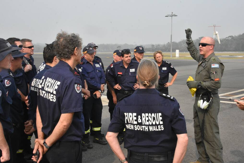 SAFETY FIRST: RAAF crew give the firefighters their safety briefing before boarding.