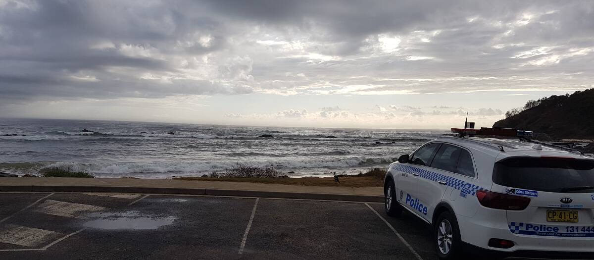 Search: A police car at Shelly Beach in Port Macquarie, on the Thursday morning of the search for two missing men.