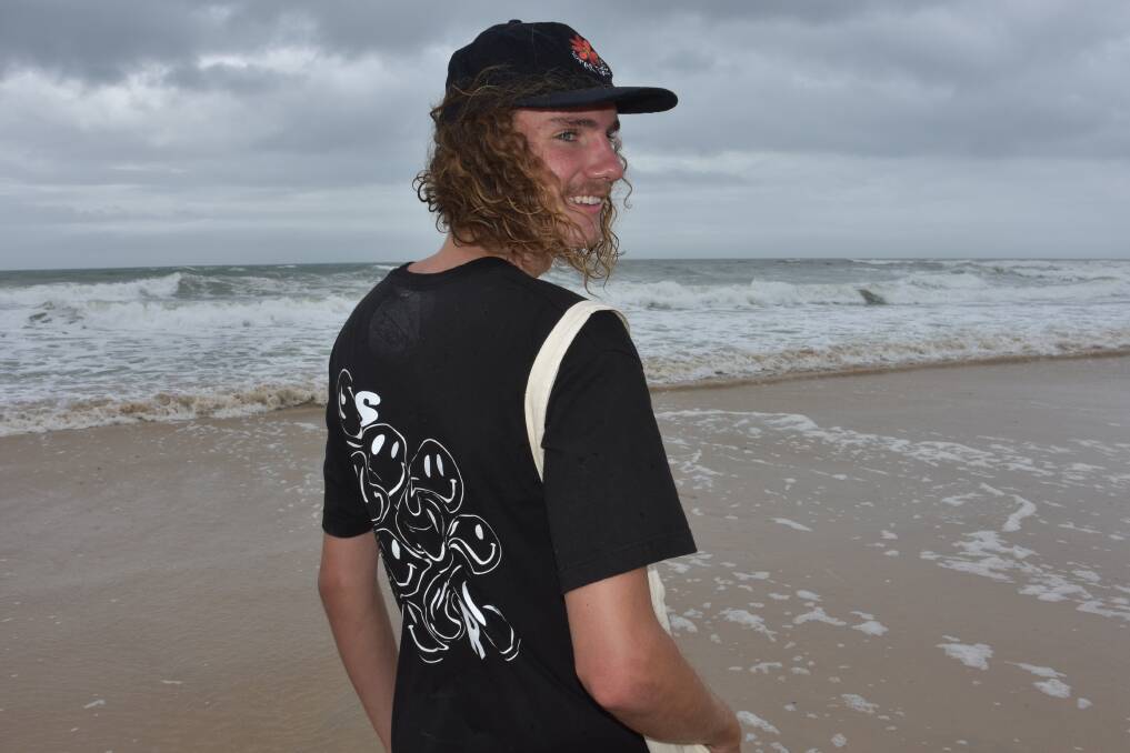 SURF AND SKATE STYLE: Entrepreneurial teenager Caelan Walker with a personally designed shirt at Rainbow Beach.