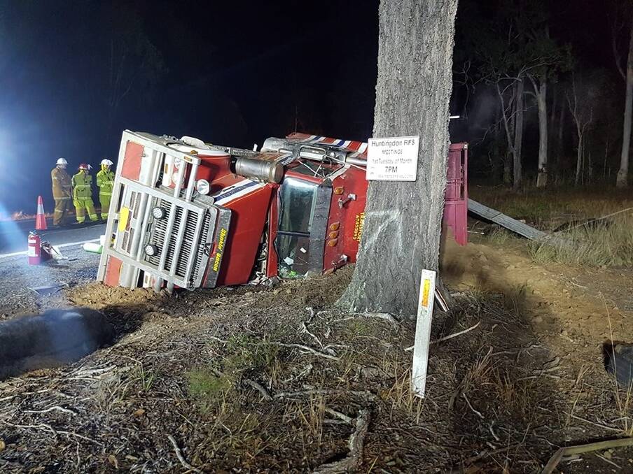Metres from a tree: Emergency services assess the cattle truck. Photo: Michael Ferguson.