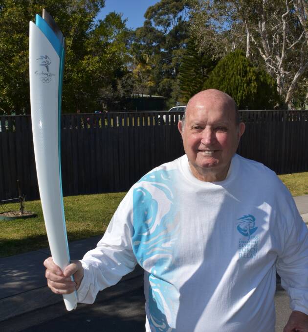 RUNNING ON AIR: Raymond Chesher the moment he ran 500 metres with the 2000 Sydney Olympic Torch.