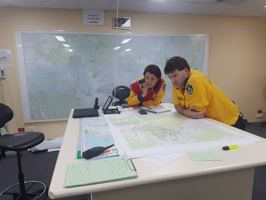 NERVOUS TIMES: NSW RFS staff study geographical maps of the area.
