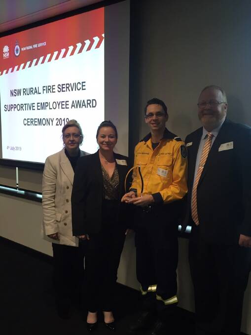 Community support: Westport Club IT manager and Lake Cathie Rural Fire Brigade deputy captain Aaron Mendham (centre right) with a NSW RFS award. Photo: Supplied.