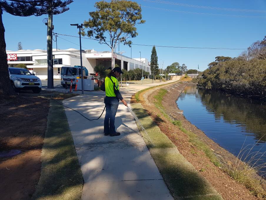 Watering the lawns: Local workmen and women putting the finishing touches on the Kooloonbung Creek foreshore.