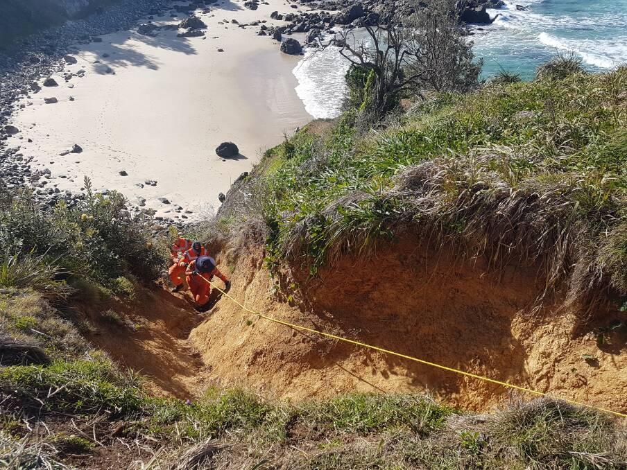 Climbing up: Port Macquarie SES volunteers using a rope to maneuver up a steep cliff.