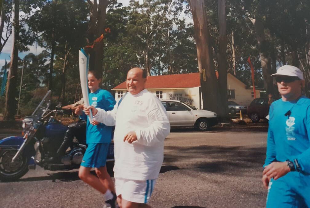 ONCE-IN-A-LIFETIME EXPERIENCE: Raymond Chesher carrying the torch in Laurieton. Photo: Supplied/Raymond Chesher.