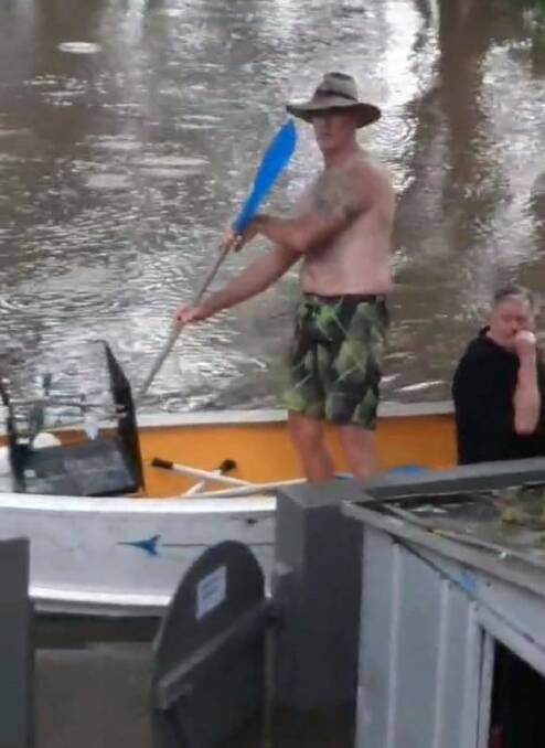 TINNY RESCUE: Glen 'Cookie' Cook paddling to rescue residents at Brigadoon Holiday Park.