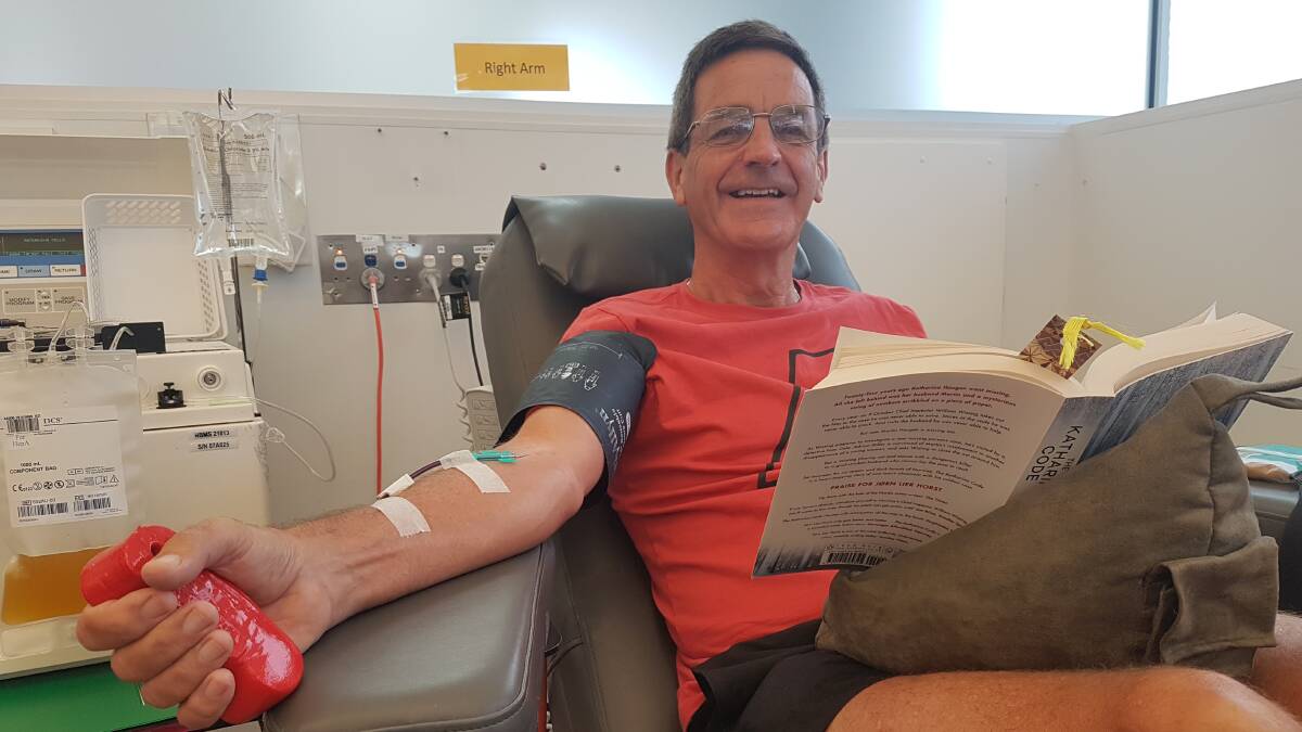 Relaxing read: Former Hastings Secondary School English teacher, Roger MacGibbon enjoys a book while giving blood.