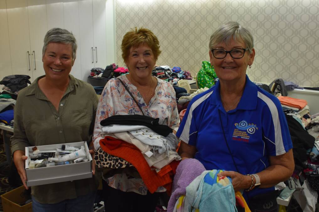 COMMUNITY SUPPORT: Volunteers Penny Smith, Wendy Barbato and Jann Muller distributing clothing and supplies at LUSC.