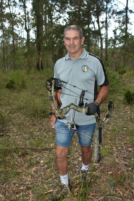 BEING A PART OF NATURE: Geoff Drew hiking with bow through bushland.