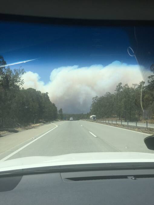 Billowing smoke is seen from the Pacific Highway about 15 kilometres south of Taree. Photo: Alana Fletcher