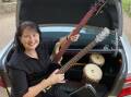 Carol Irving packs the car with donated musical instruments bound for Lismore. Photo supplied