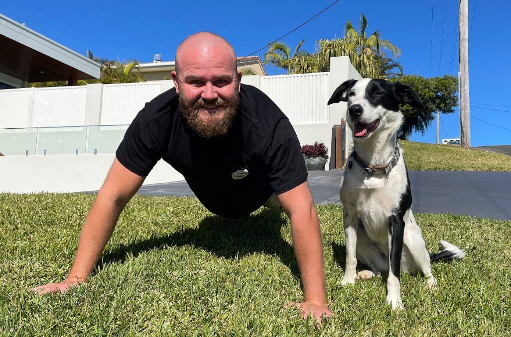 Josh Hunter prepares for The Push-Up Challenge with encouragement from his dog Maggie. Picture by Lisa Tisdell