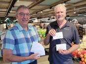 Wauchope Rotarian Neville Parsons and Hastings Co-op business and community development manager Tim Walker with the donated fuel vouchers.
