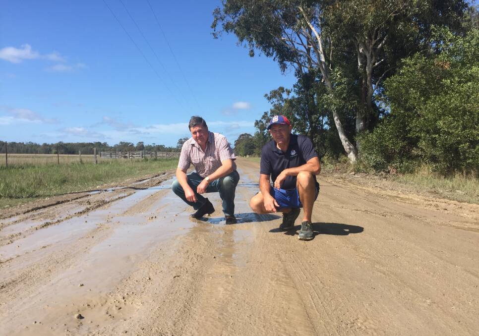 Muddy mess: Residents Stuart Redman and Rick Flanagan inspect a section of The Hatch Road. The Hatch Road runs off Blackmans Point Road.
