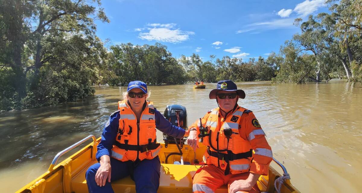 Marine Rescue Port Macquarie member Ali Cameron-Brown (left) and a Port Stephens SES volunteer on a boat to set up markers to guide the way for safe entry and exit points to the flooded Barwon River. Picture supplied