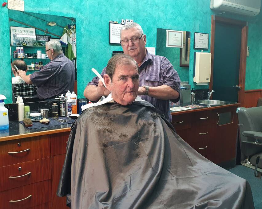  Experienced barber: Richard Moy cuts John Bishop's hair as business gradually picks up at the barber shop.