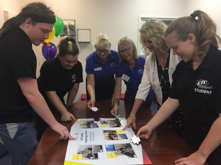 Making history: Aged care students Tyran Binskin and Chelsea Evenden, aged care trainer Rhonda Wilkie, training manager Paula Skinner, chief executive officer Jenny Barnett and aged care student Velvet Burkhardt put the final touches on a puzzle which will be framed as a plaque to mark the official opening.