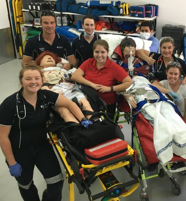 Bright future: Charles Sturt University Bachelor of Clinical Practice (Paramedic) student Hannah Stack (centre) assists other students. Hannah won the John Overton Award in recognition of her leadership and research.