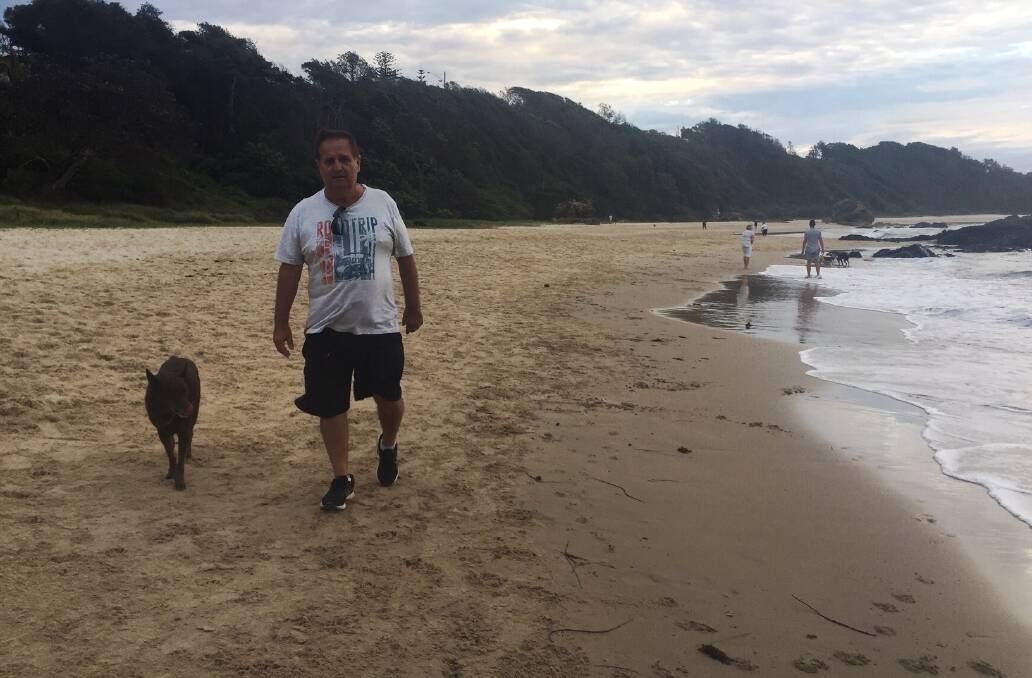 Happy days: Ray Thompson and his dog Red make the most of Nobbys Beach in Port Macquarie.