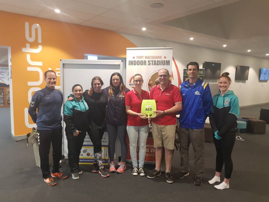 Combined effort: Mick Day (East Coast Futsal), Angy Dixon (Port Macquarie Gymnastics), Lexi Wilson (Game over Cafe), Rachel Stephan (IFMG), Isabella Harrison (Student Heart Project), Adam Lawes (The Defib Shop/Student Heart Project), Mark Newman (Port Macquarie Basketball) and Caitlyn Lee (Port Macquarie Gymnastics) at the defibrillator handover.