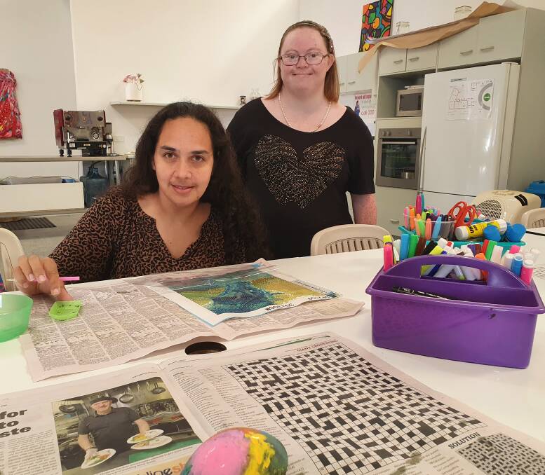 Art in action: NDIS participant Trish Gray creates an artwork as Absolutely Everybody Choir member Lisa Jones looks on.