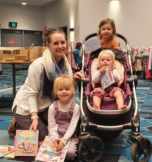 Love of books: Carissa Rumble and her daughters Audrey, Isla and Scarlett look for children's books at the Giant Book Sale.