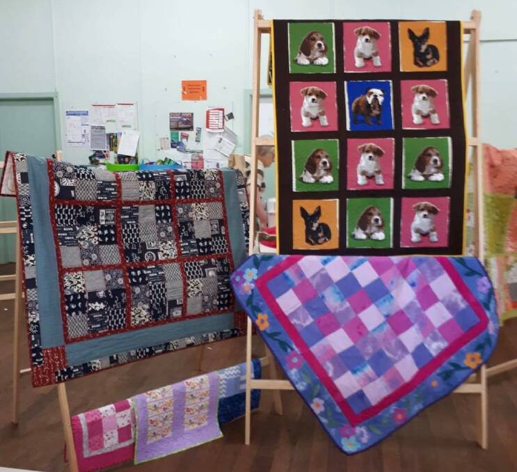 A selection of quilts set up on stands made by Wauchope Men's Shed. Photo: Wauchope Patchwork Quilters