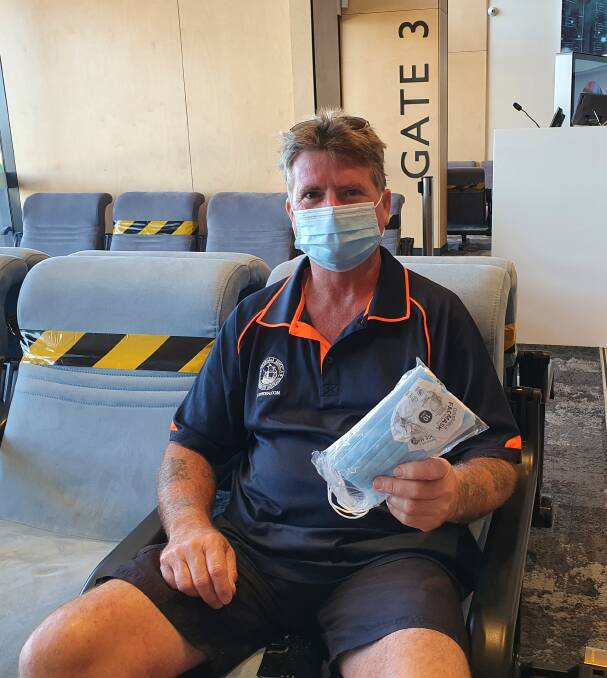 Safety first: Jim Henry wears a face mask at Port Macquarie Airport before boarding a flight.