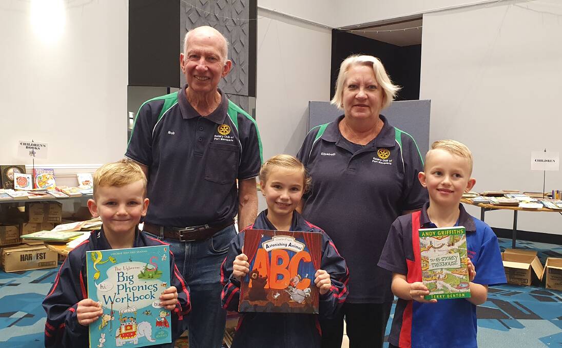 Meaningful donation: Telegraph Point Public School students Oliver, Grace and Harrison Bollard (front) help out with the book selection with support from Rotary Club of Port Macquarie book sale coordinator Bob Cleland and Rotary Club of Port Macquarie president Elizabeth Fielding.