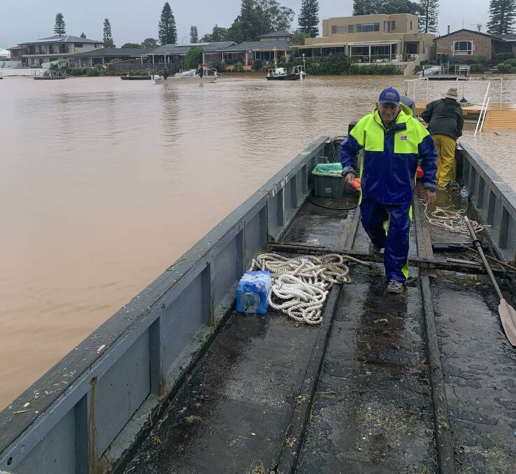On the water: Robert Herbert and Ian Macca prepare an oyster punt as part of the flood relief effort.
