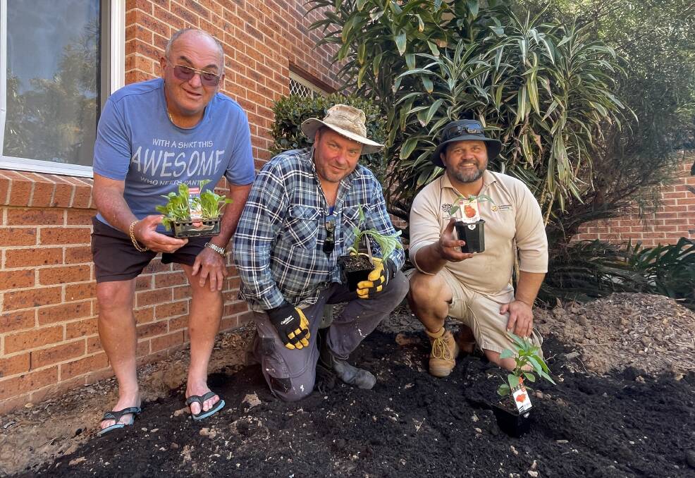 Resident Peter Lewis, Steve Neale from Community Housing Limited and Botanic Gardens of Sydney's Brenden Moore pitch in to help plant the garden. Picture by Lisa Tisdell
