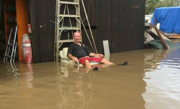 Volunteer Wayne Marsden amid the floodwater. Photo: Neville Cooke