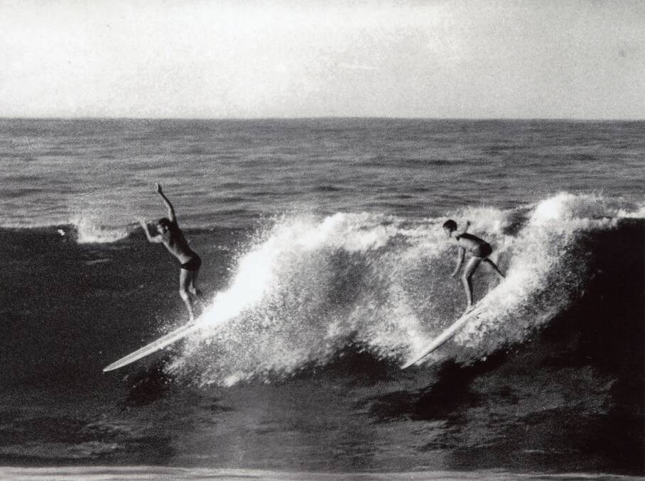 Flashback: Jonny Holmes and Brian Worth surf at Flynns Beach circa 1960s.