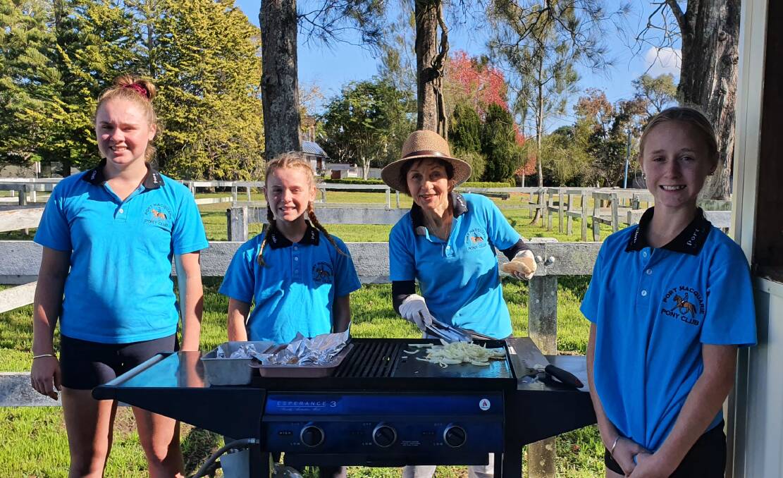 Fundraising day: Port Macquarie Pony Club's Judy Cooper (third from left) is in charge of the sausage sizzle while Ava, Mia and Ivy Basanovic look on.