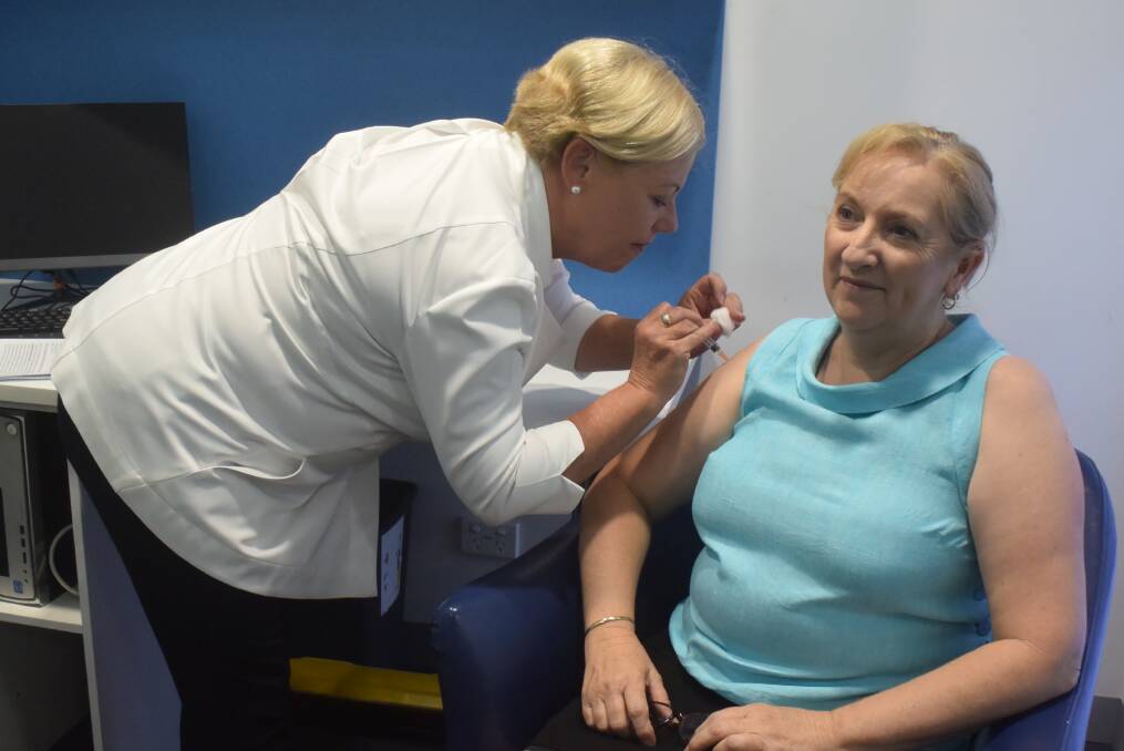 Healthy choice: Community pharmacist Judy Plunkett vaccinates Pat Roser against whooping cough.