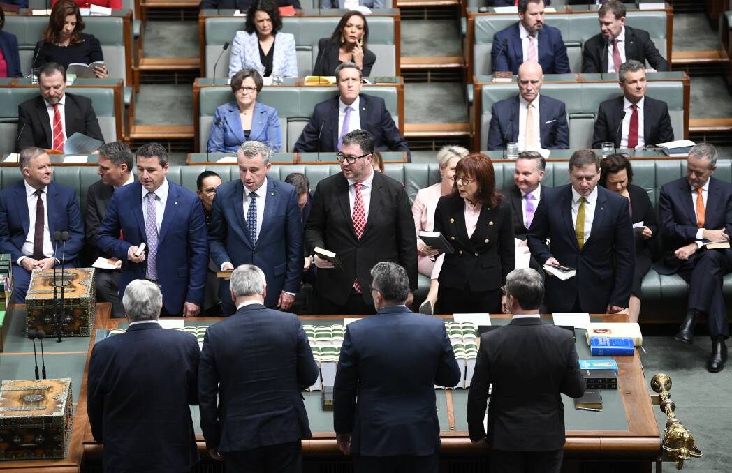 New chapter: The incoming Cowper MP Pat Conaghan takes his first oath of office alongside fellow MPs in the Australian Parliament House. Photo: Auspic/DPS