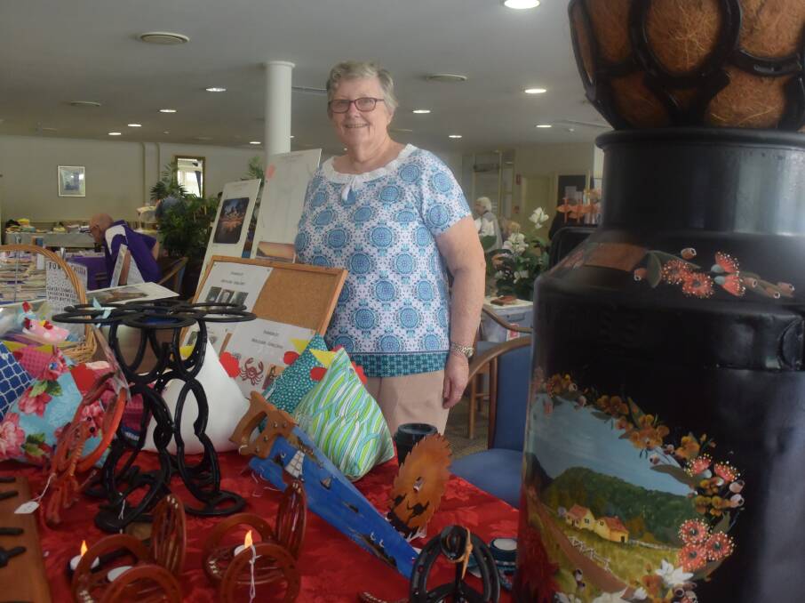 Cathy Wagstaffe looks after a stall featuring her husband's horseshoe art.