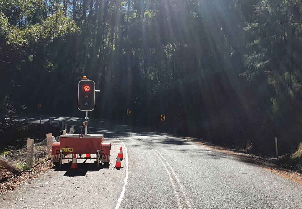 Safety measure: Portable traffic lights control the traffic flow on a single-lane section of Comboyne Road.